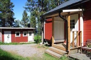 a red and white cabin with a porch and stairs at Aurora Camp Kurravaara in Kurravaara