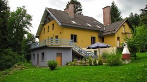 a yellow house with a porch and a balcony at Krokus in Piechowice
