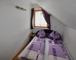 ドナースバッハヴァルトにあるHaus Schindelbacherの小さなベッドルーム(紫色のベッド1台付)が備わる屋根裏部屋です。