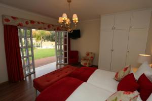 a bedroom with a large bed and a red couch at Villa Moringa Guesthouse in Windhoek
