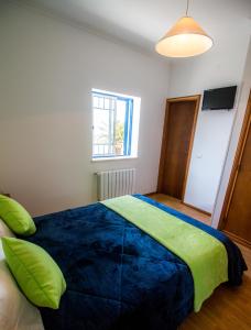 een slaapkamer met een groot bed en een blauwe deken bij Quarto Crescente in Nazaré