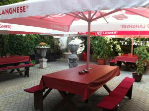 a table with an umbrella and two chairs under it at Hotel Zum Goldenen Löwen in Merseburg