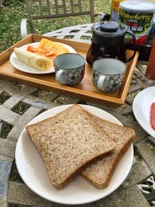 a sandwich on a plate on a table with two cups at Baisha 31 B&B in Hengchun
