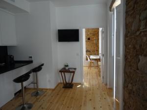 uma sala de estar com paredes brancas e piso em madeira em Alojamentos Casa Facha Papaia em Portalegre