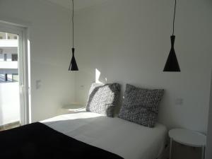 um quarto com uma cama branca e 2 almofadas em Alojamentos Casa Facha Papaia em Portalegre