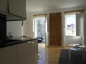 a kitchen with a counter and a window and a table at Alojamentos Casa Facha Papaia in Portalegre