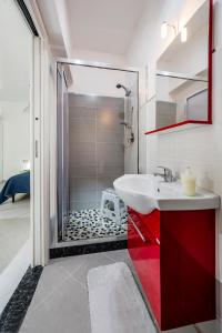 W łazience znajduje się czerwona umywalka i prysznic. w obiekcie Le Case di Katy w mieście Castellammare del Golfo +47 zdjęć