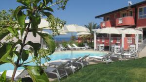 a pool with chairs and umbrellas next to a building at Borgo di Santa Barbara in Santa Domenica
