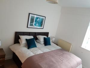 uma cama com duas almofadas azuis em cima em Norfolk House em Southampton