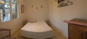 une chambre avec un lit dans l'angle d'une pièce dans l'établissement Le Club des Cigales, à Hyères
