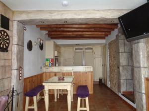 a kitchen with a table and some purple chairs at Columbaira in Colomera