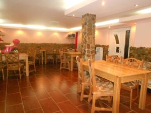 een eetkamer met houten tafels en stoelen bij Casa Bryanna in Cavnic