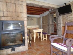 a living room with a fireplace and a tv at Columbaira in Colomera