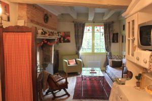 a living room with a couch and a fireplace at Le Relais de La Myrpe in Bergerac