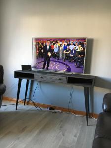 TV de pantalla plana sentada en una mesa en una habitación en Christiesholidayhomes en Aviemore