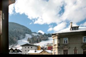 widok na miasto z pokrytą śniegiem górą w obiekcie City Apartments Mozart w mieście Zell am See