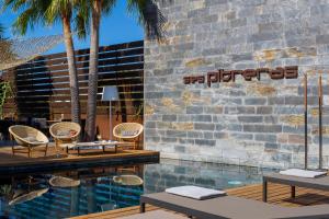 a resort with a swimming pool and palm trees at Hotel Boutique Ses Pitreras in San Antonio Bay