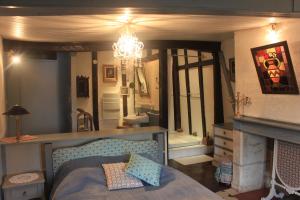 a bedroom with a bed and a fireplace and a chandelier at Le Relais de La Myrpe in Bergerac