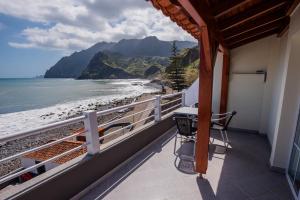 uma varanda com uma mesa e vista para a praia em Hotel Costa Linda em Porto da Cruz