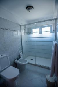 a bathroom with a toilet and a glass shower at Hotel Costa Linda in Porto da Cruz