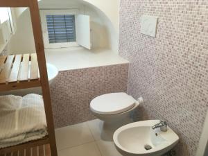 La petite salle de bains est pourvue de toilettes et d'un lavabo. dans l'établissement Casa Vacanze Pizzicantò, à Irsina