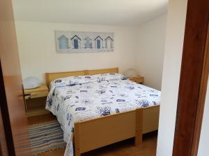 Schlafzimmer mit einem Bett mit einer blauen und weißen Bettdecke in der Unterkunft B&B villa sofà in Capo Vaticano