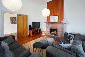 a living room with a couch and a fireplace at Oakura Bay Villa - Stay Waiheke in Te Whau Bay
