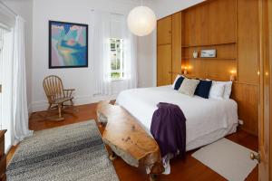 a bedroom with a large bed with a wooden headboard at Oakura Bay Villa - Stay Waiheke in Te Whau Bay