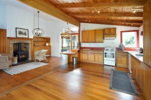 a large kitchen with wooden cabinets and a fireplace at Oakura Bay Villa - Stay Waiheke in Te Whau Bay +34 photos
