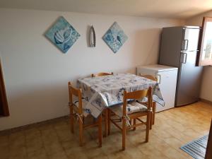 cocina con mesa, sillas y nevera en B&B villa sofà, en Capo Vaticano