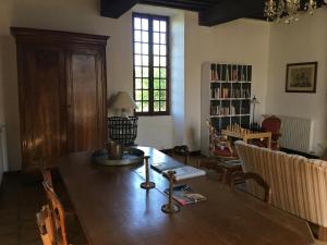 uma sala de jantar com uma mesa de madeira e cadeiras em Le Vieux Château de Saint Martin-Lars em Saint-Martin-Lars-en-Sainte-Hermine