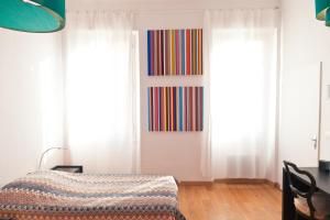 カンヌにあるFestival Apartmentの白いカーテンとベッドが備わる客室です。