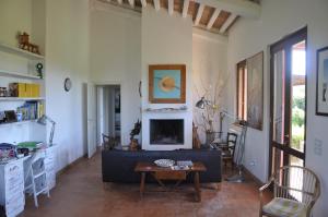 a living room with a couch and a fireplace at Stalla Lunga in Magliano in Toscana