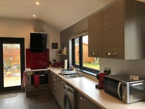 a kitchen with a sink and a microwave at The Wee Lodge in Inverness