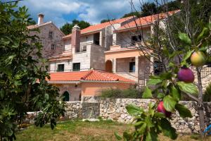 a large house with a stone wall in front of it at Villa Marija Podgora in Podgora