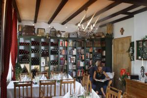 a man sitting at a table in a room with books at Landhotel Becker in Kamp-Bornhofen