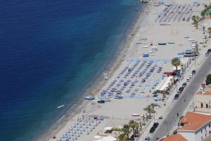 CatonaにあるLa Veranda sul Mareのビーチの空中を望む客室で、椅子とパラソルが備わります。