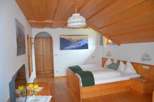 a bedroom with a bed and a wooden ceiling at Falkenau in Chienes