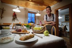 a woman sitting at a table in a kitchen at Falkenau in Chienes