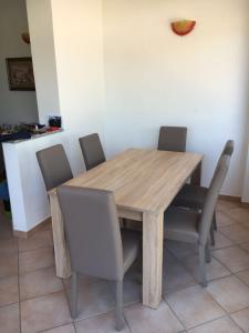 een houten tafel met zes stoelen eromheen bij Villa La Pila in Campo nell'Elba