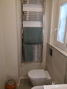 een badkamer met een toilet en een raam met handdoeken bij Morandi's in Bologna
