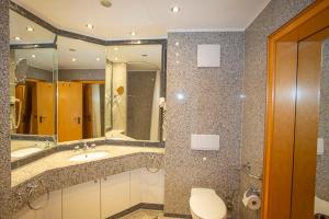 ein Badezimmer mit einem Waschbecken, einem WC und einem Spiegel in der Unterkunft Apartment 85 im Dünenpark in Binz