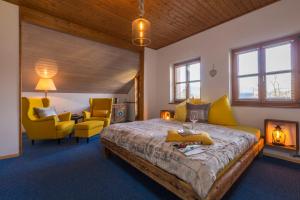 a bedroom with a bed and two yellow chairs at GIRBL bio ZIMMER in Strobl
