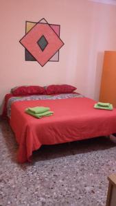 タルサノにあるAffittacamere di Fabio Principaleのベッドルーム1室(赤いベッド1台、タオル2枚付)