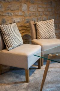 two chairs and a glass coffee table in a room at Villa Des Ursulines in Bayeux