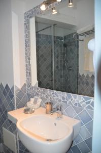 a bathroom with a sink and a mirror at Hotel Il Timone in Cugnana