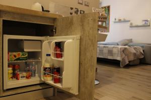 a small refrigerator with its door open in a room at Sissi B&B in Pozzuoli