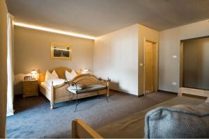 a hotel room with a bed and a couch at Furggerhof in Tirolo
