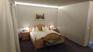 a bedroom with a bed and two night stands with lamps at Furggerhof in Tirolo