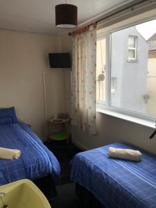 a hotel room with two beds and a window at The Merlin Hotel in Blackpool